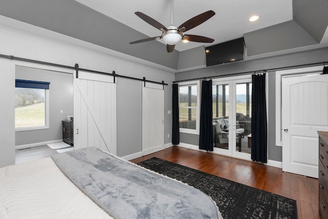 bedroom featuring vaulted ceiling, hardwood / wood-style floors, access to exterior, ceiling fan, and a barn door