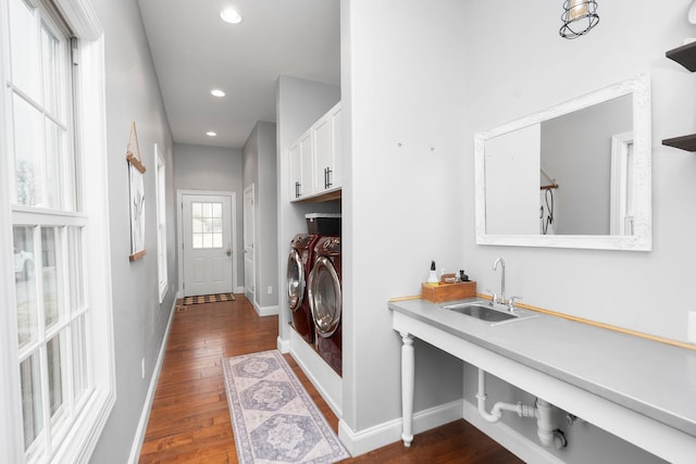 laundry area with cabinets, washing machine and dryer, sink, and dark hardwood / wood-style flooring