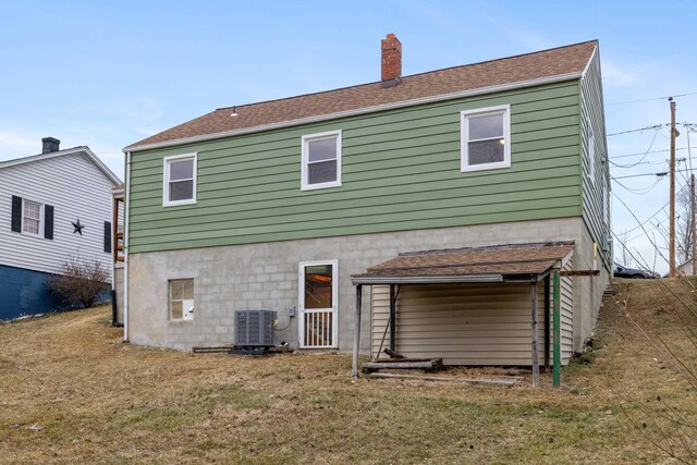 rear view of house with a yard and central air condition unit