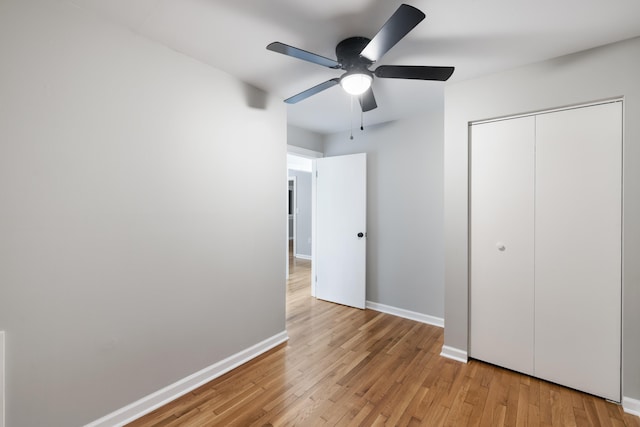 unfurnished bedroom featuring a closet, ceiling fan, and light wood-type flooring