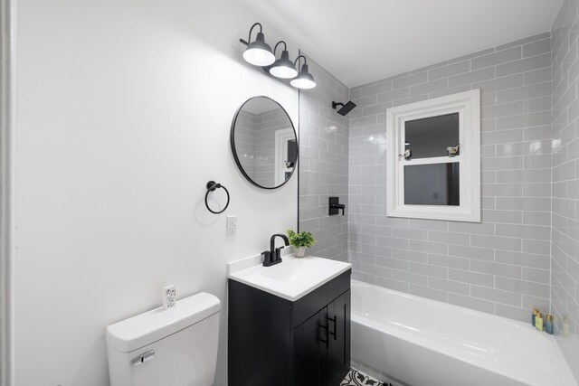 full bathroom with vanity, tiled shower / bath combo, and toilet