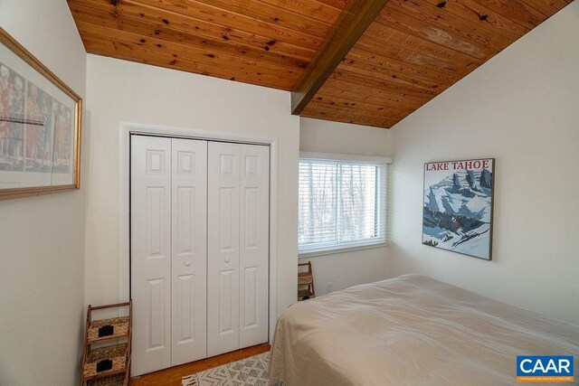 bedroom featuring lofted ceiling, wood ceiling, a closet, and wood finished floors