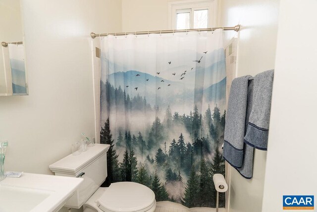 full bathroom with a shower with shower curtain and toilet