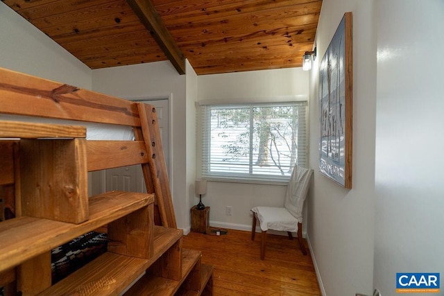 bedroom with lofted ceiling with beams, wood finished floors, wood ceiling, and baseboards