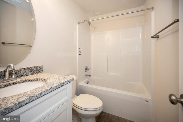 full bathroom with hardwood / wood-style flooring, vanity, toilet, and shower / washtub combination