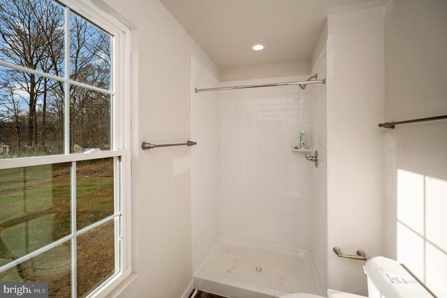 bathroom featuring toilet and a tile shower