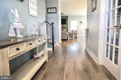 hallway with stairway, dark wood finished floors, and baseboards