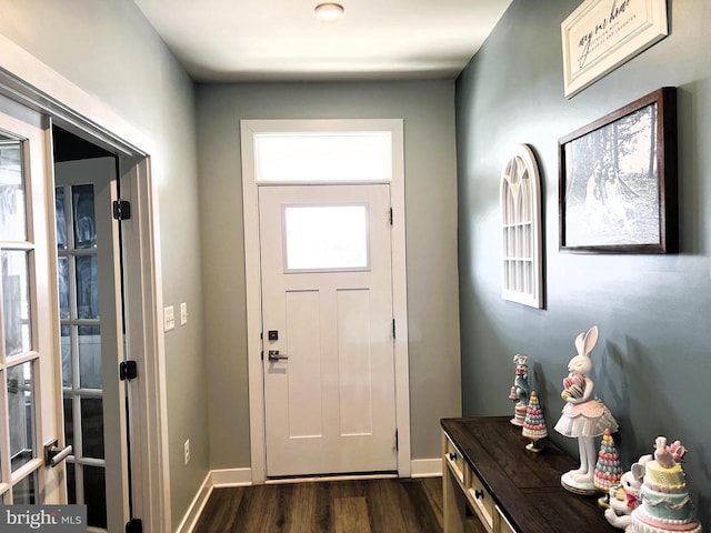 foyer entrance with dark wood-type flooring and baseboards