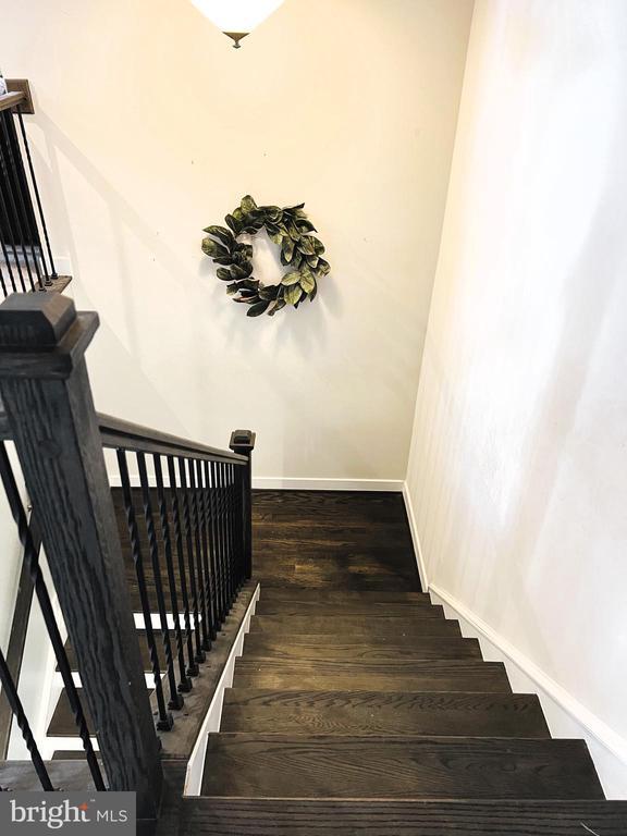 stairway featuring baseboards and wood finished floors