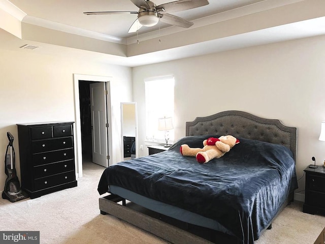 bedroom with ornamental molding, visible vents, light carpet, and a ceiling fan