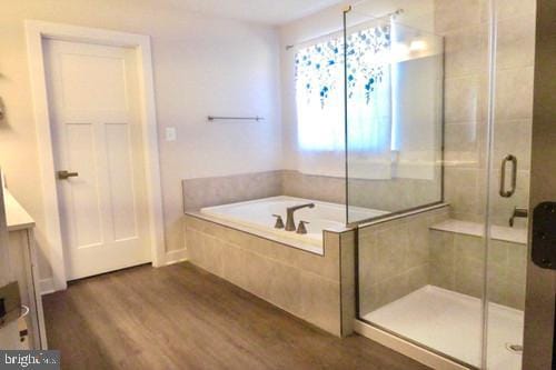 full bath featuring a garden tub, vanity, wood finished floors, and a stall shower