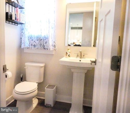 bathroom featuring baseboards, a sink, and toilet