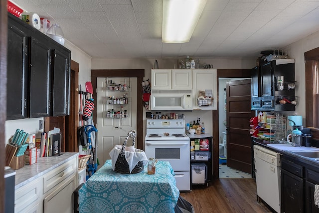 kitchen with white appliances, white cabinetry, dark wood finished floors, and light countertops