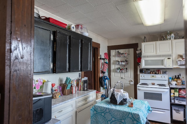 kitchen featuring white appliances, white cabinetry, and dark cabinets