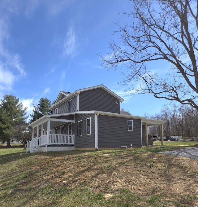 view of side of home with a porch and a lawn