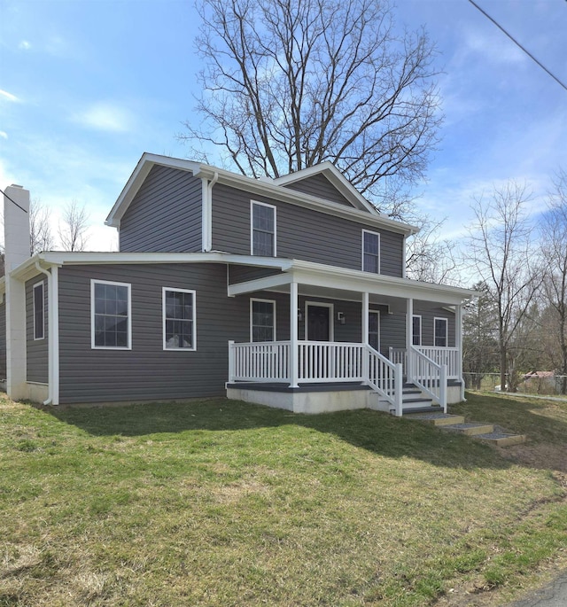 view of front of property with a porch, a chimney, and a front lawn