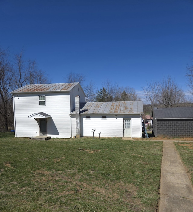 exterior space featuring a yard, metal roof, and a standing seam roof