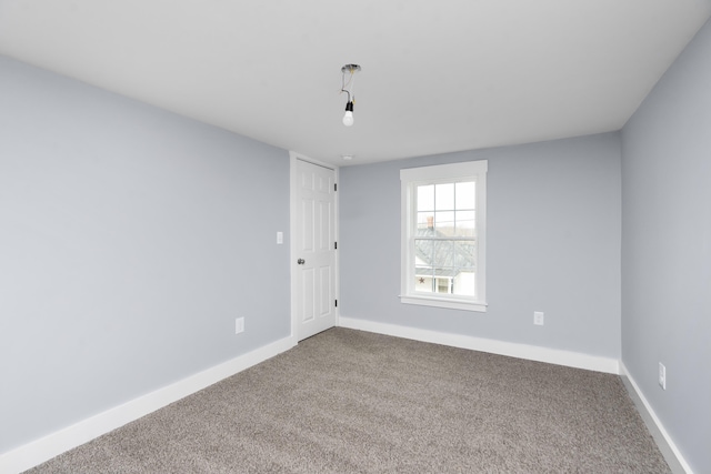 unfurnished room with carpet floors and baseboards