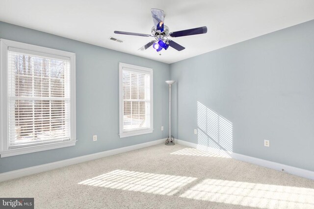 spare room with plenty of natural light, light carpet, and ceiling fan