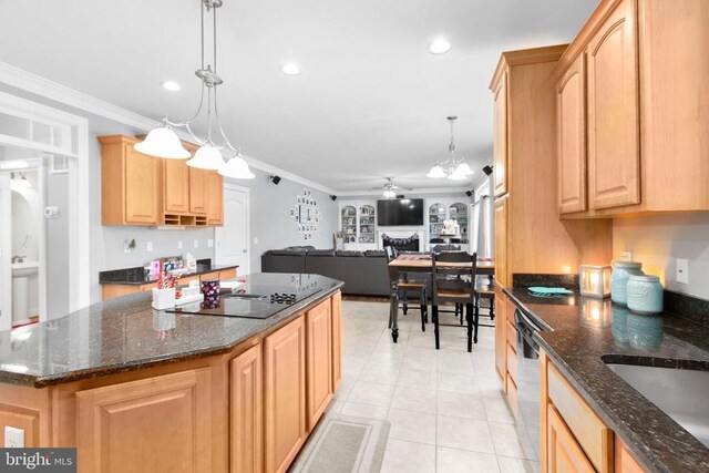 kitchen featuring crown molding, dark stone counters, decorative light fixtures, and a kitchen island