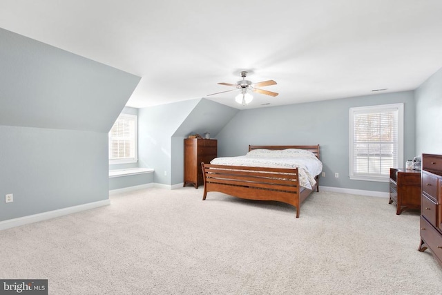 carpeted bedroom with multiple windows, vaulted ceiling, and ceiling fan