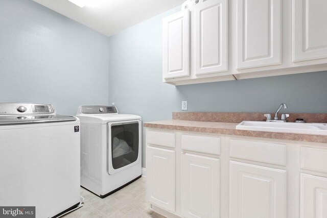 laundry area with sink, cabinets, and washing machine and clothes dryer