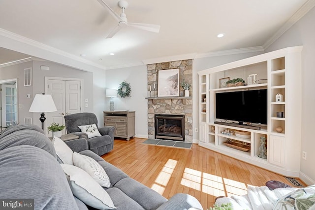 living room with crown molding, a fireplace, visible vents, and wood-type flooring