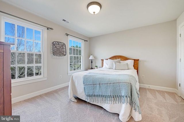 carpeted bedroom featuring visible vents and baseboards