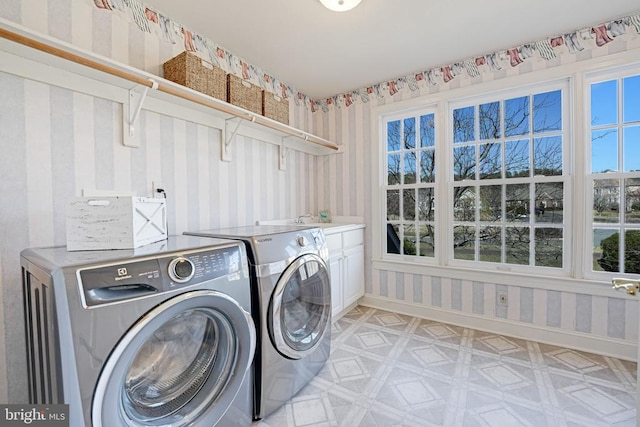 washroom with washer and clothes dryer, cabinet space, wallpapered walls, baseboards, and light floors