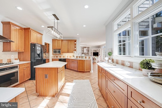 kitchen featuring light countertops, light tile patterned floors, a peninsula, black appliances, and a sink