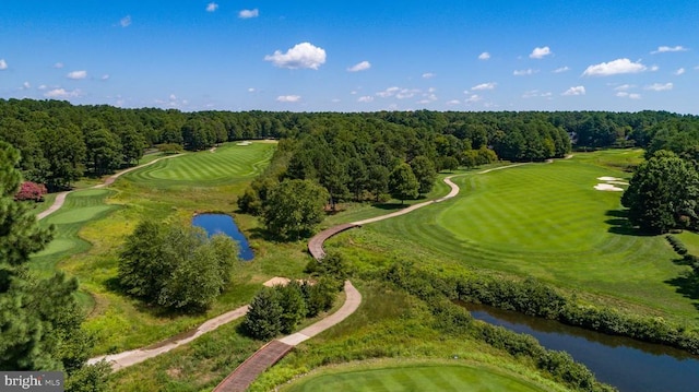 birds eye view of property featuring a water view, view of golf course, and a wooded view