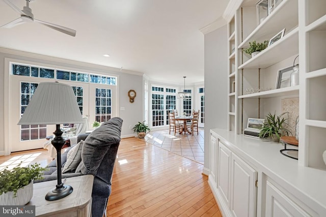 living room with ornamental molding, a ceiling fan, recessed lighting, light wood-style floors, and baseboards