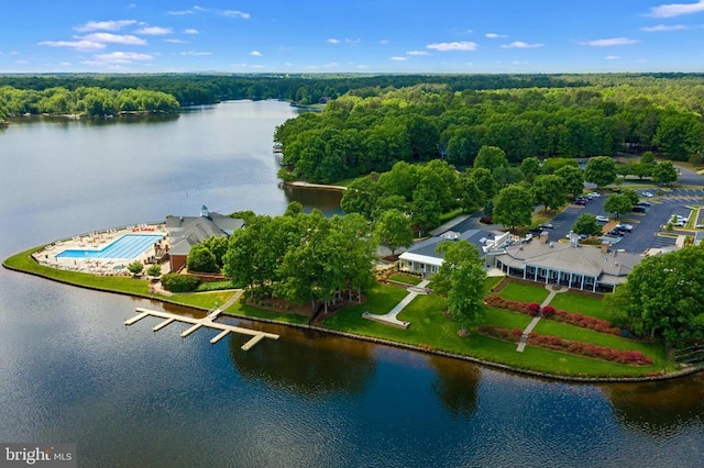 birds eye view of property featuring a water view and a wooded view