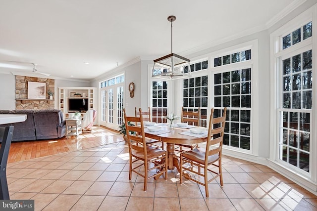 dining room featuring an inviting chandelier, light tile patterned floors, french doors, and ornamental molding