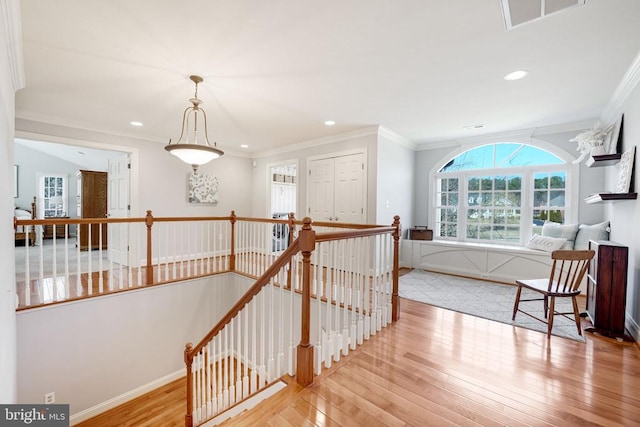 corridor with an upstairs landing, recessed lighting, ornamental molding, and hardwood / wood-style floors