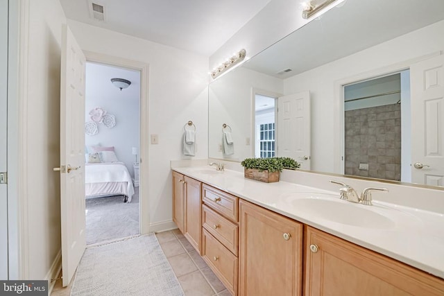 ensuite bathroom featuring a sink, visible vents, double vanity, and tile patterned flooring