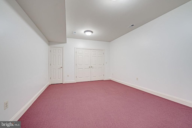 empty room with visible vents, baseboards, and dark carpet