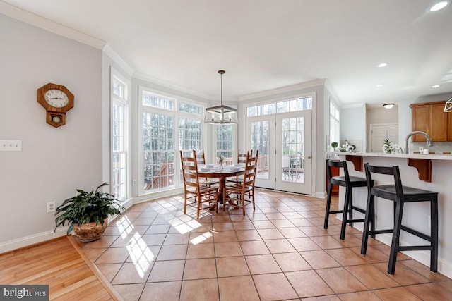 dining room featuring light tile patterned floors, baseboards, and crown molding