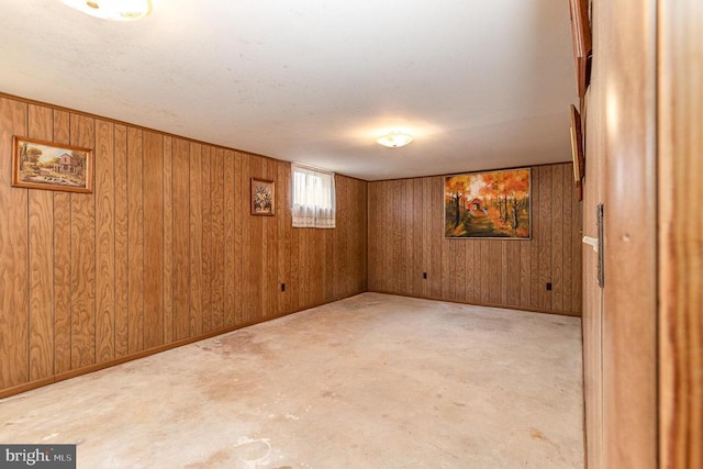 basement featuring baseboards and wooden walls