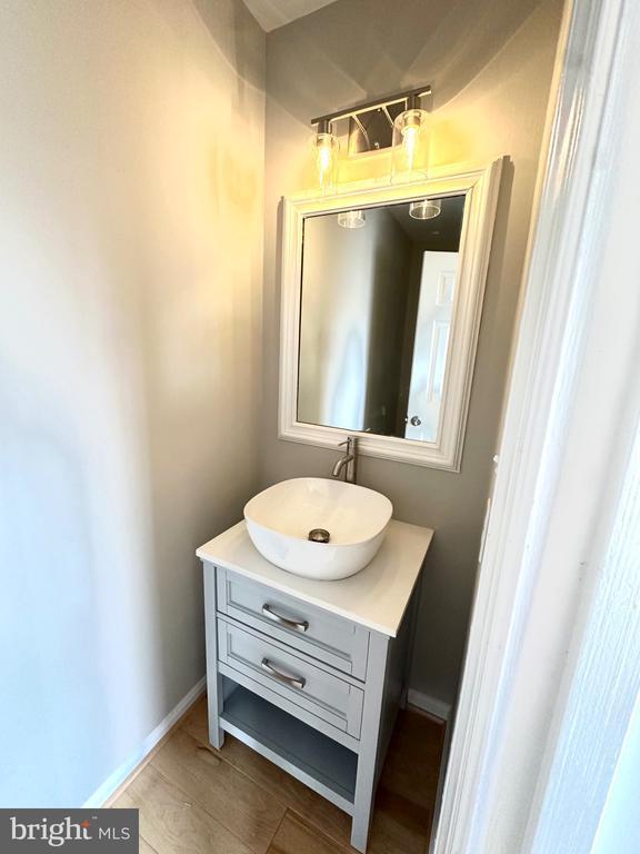 bathroom featuring baseboards, wood finished floors, and vanity