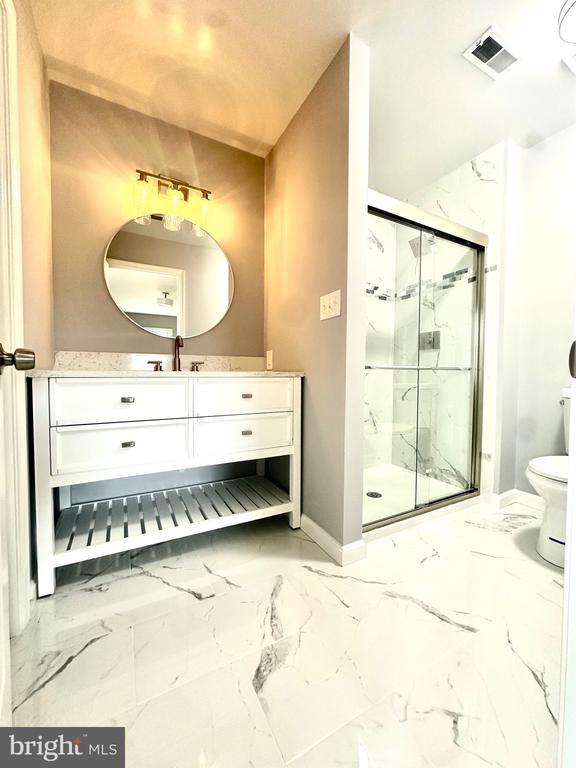 full bathroom with visible vents, a marble finish shower, marble finish floor, and baseboards