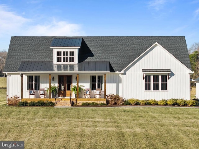 modern farmhouse featuring a front lawn, a standing seam roof, a porch, roof with shingles, and metal roof