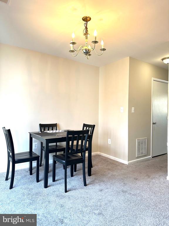 dining space featuring carpet floors and a chandelier