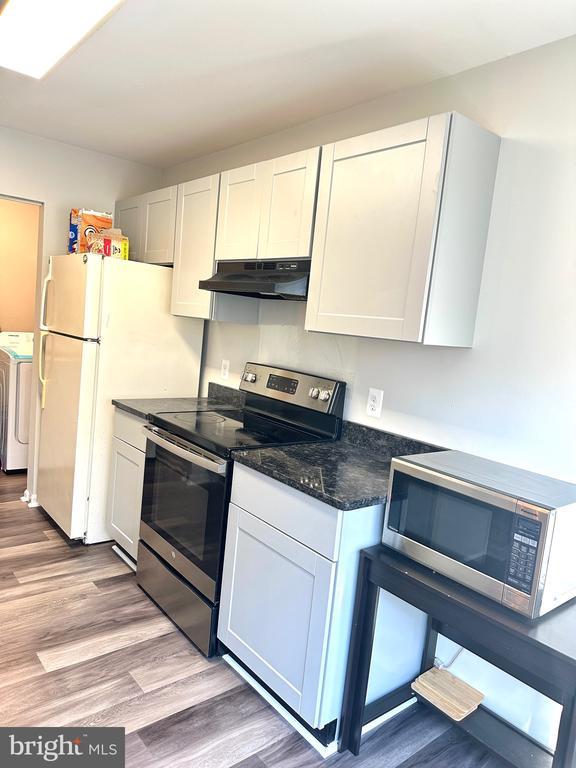 kitchen featuring white cabinetry, stainless steel appliances, and independent washer and dryer