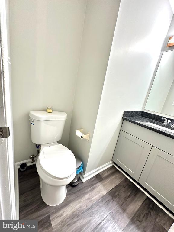 bathroom featuring vanity, hardwood / wood-style flooring, and toilet