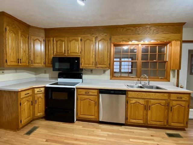 kitchen featuring light hardwood / wood-style floors, sink, and black appliances