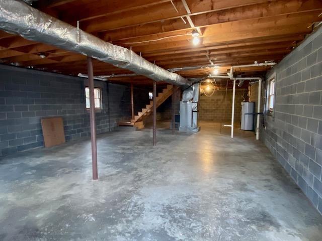 basement featuring heating unit and water heater