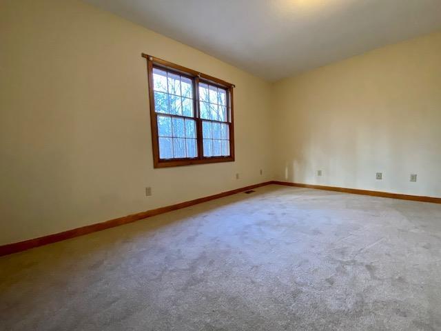 empty room featuring vaulted ceiling and carpet