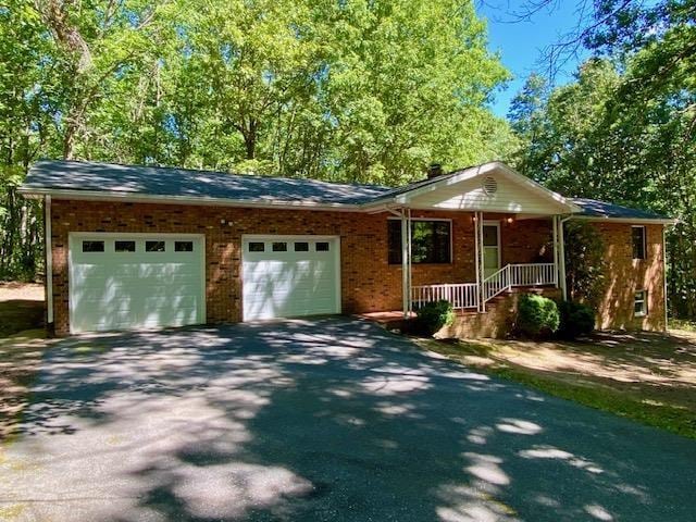 ranch-style home with a garage and a porch