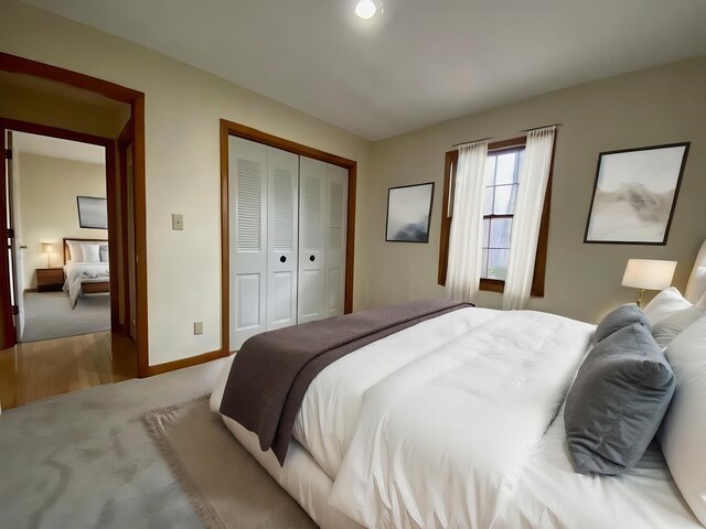 bedroom featuring light colored carpet and a closet